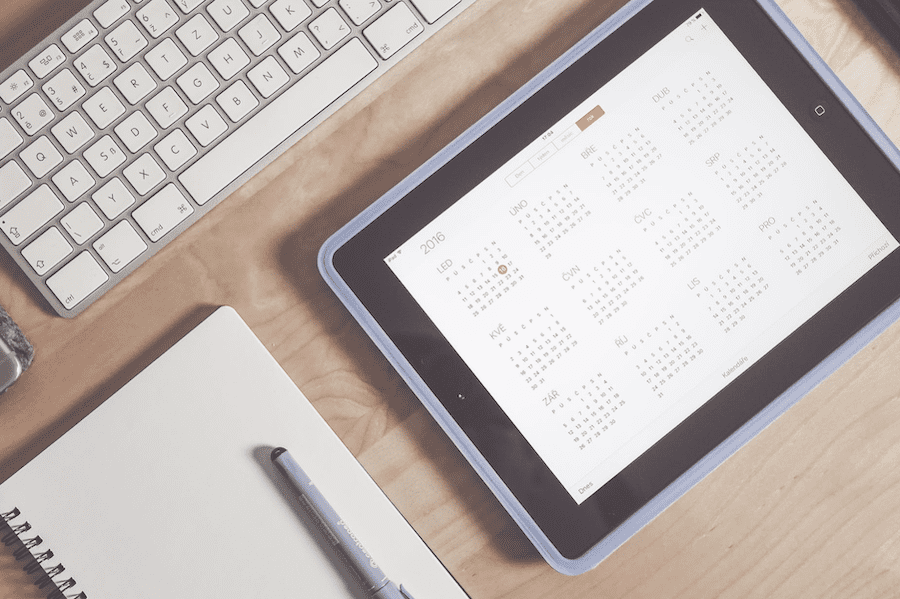 computer keyboard and tablet with calendar showing